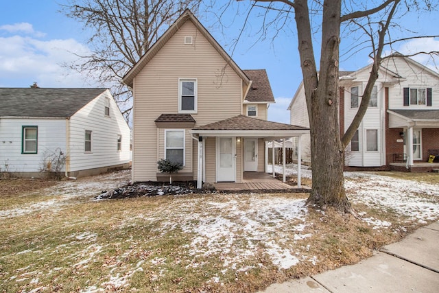 traditional home with a porch and a shingled roof