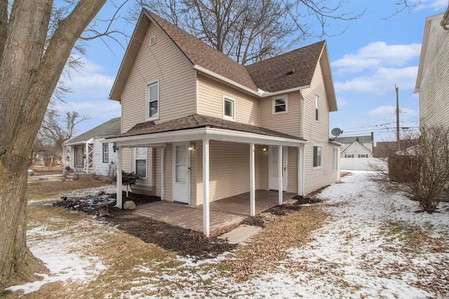 exterior space with a porch and roof with shingles