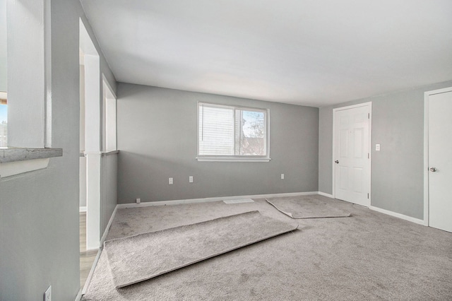 carpeted empty room featuring baseboards
