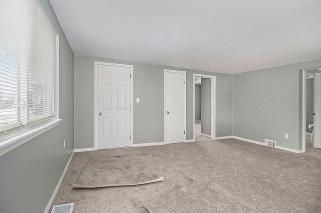 interior space with baseboards, carpet, and visible vents