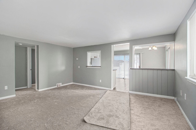 carpeted spare room with baseboards and visible vents