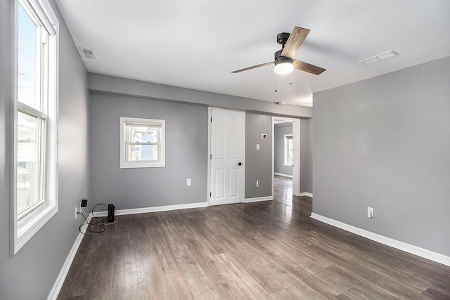unfurnished room with baseboards, ceiling fan, visible vents, and wood finished floors
