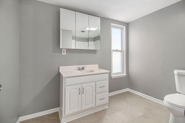 half bath featuring baseboards, toilet, and vanity