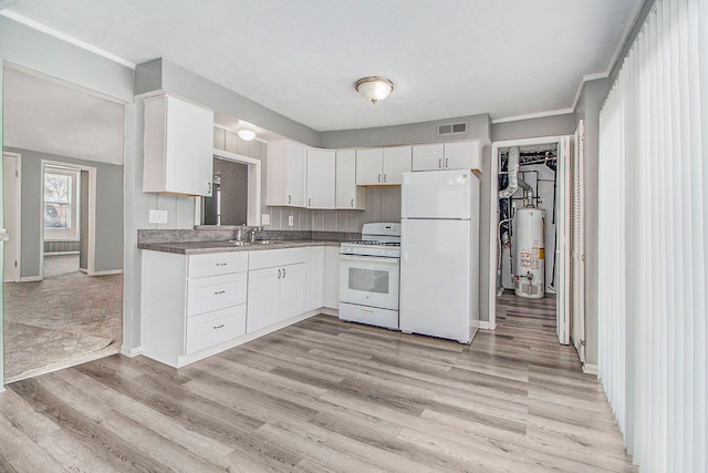 kitchen with visible vents, white appliances, gas water heater, white cabinets, and a sink