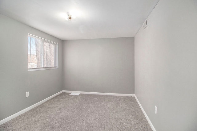 carpeted empty room featuring baseboards and visible vents