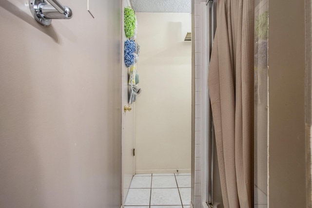bathroom with tile patterned flooring, baseboards, and curtained shower