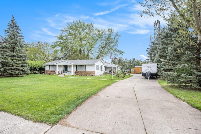 ranch-style house featuring concrete driveway, covered porch, and a front yard