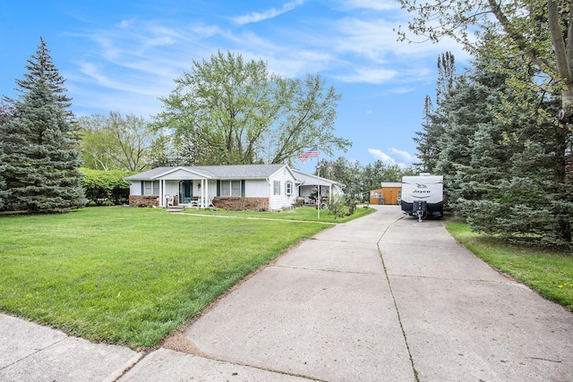 view of front of home with covered porch, a chimney, concrete driveway, and a front lawn