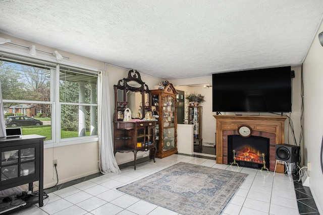 tiled living area featuring baseboards, a textured ceiling, and a brick fireplace