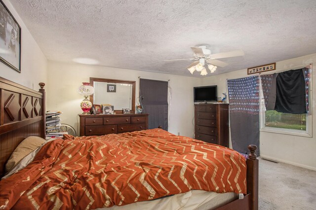 carpeted bedroom with baseboards, ceiling fan, and a textured ceiling