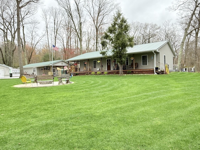 back of property featuring a porch, board and batten siding, a lawn, and metal roof