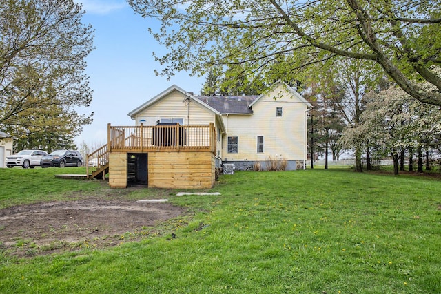 back of property with a wooden deck, stairs, and a lawn