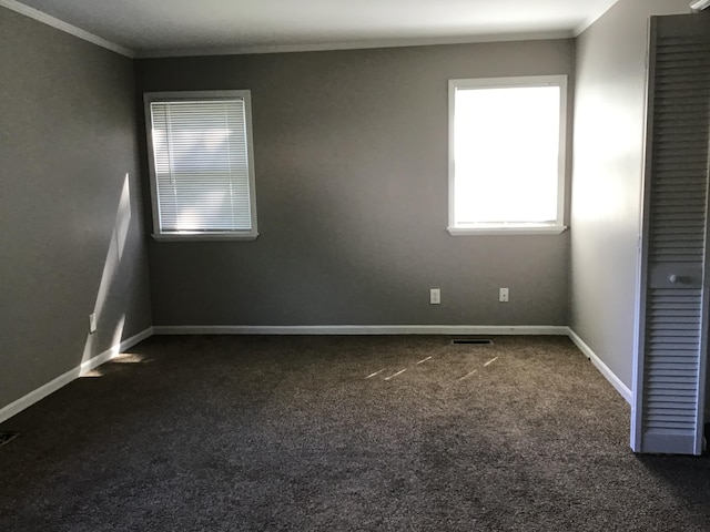 23822 Wellington Ave, Warren, MI 48089 - spare room featuring crown molding, baseboards, dark colored carpet, and visible vents