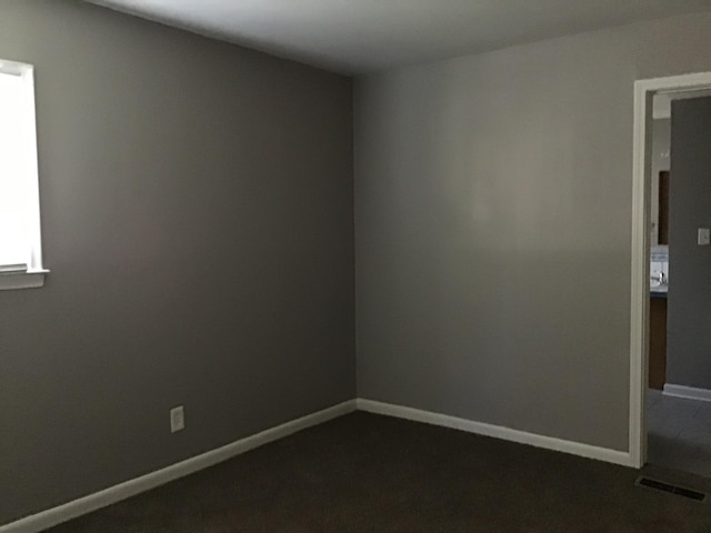 23822 Wellington Ave, Warren, MI 48089 - spare room featuring baseboards, dark carpet, and visible vents