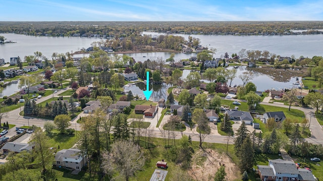 aerial view of property and surrounding area with a nearby body of water and nearby suburban area