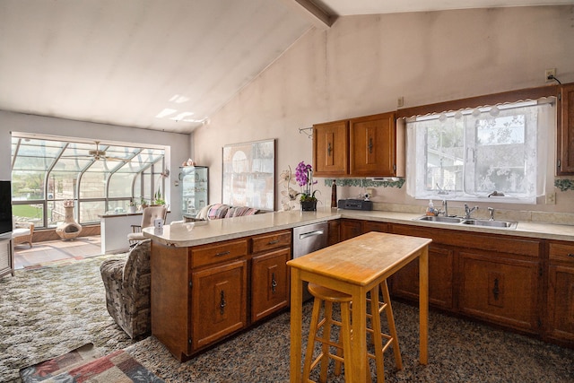 kitchen featuring a sink, a peninsula, light countertops, brown cabinetry, and high vaulted ceiling