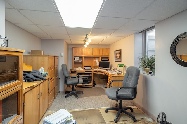 home office with light colored carpet, a paneled ceiling, rail lighting, and baseboards