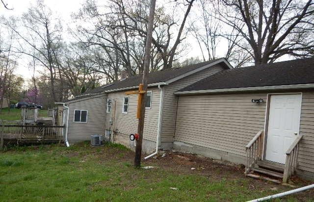 view of side of property featuring a deck, central AC unit, and entry steps
