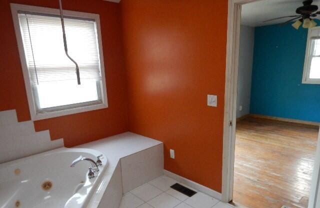 bathroom featuring a ceiling fan, baseboards, visible vents, and a whirlpool tub