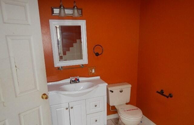 bathroom featuring vanity, tile patterned floors, and toilet