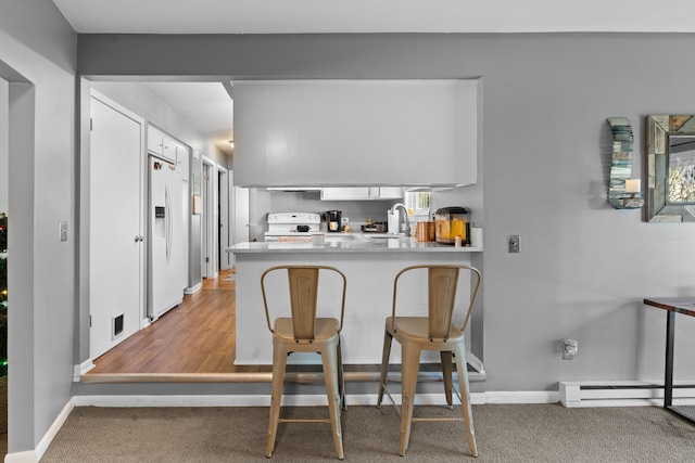 5874 Thornaby Dr, Waterford, MI 48329 - kitchen with a peninsula, white fridge with ice dispenser, a sink, carpet floors, and baseboards