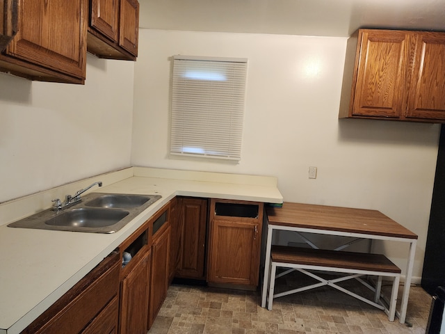 kitchen with a sink, brown cabinets, and light countertops