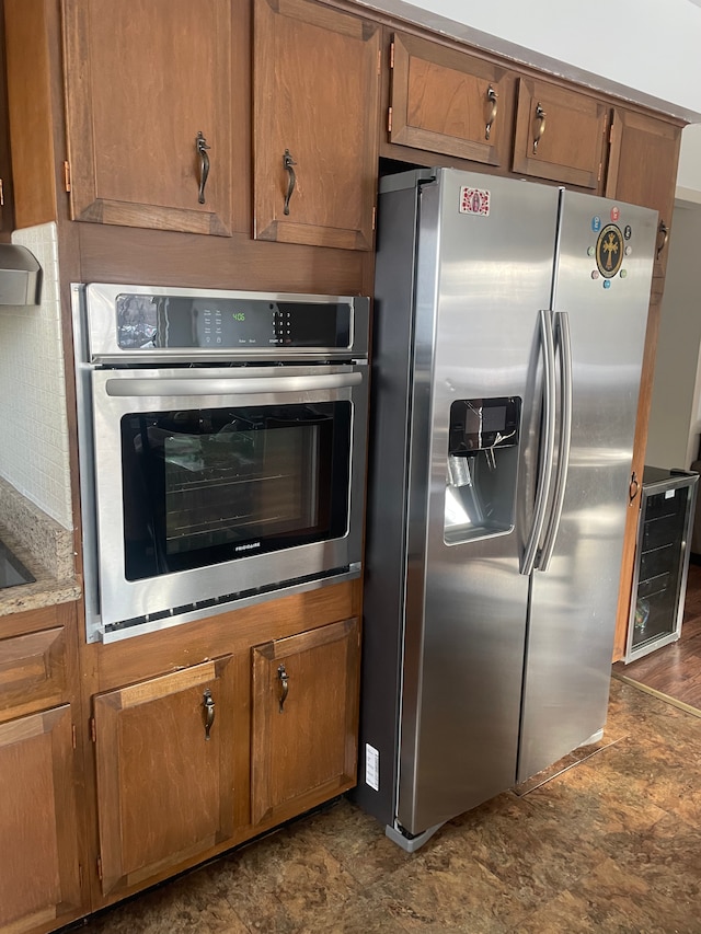 11916 Geoffry Dr, Warren, MI 48093 - kitchen featuring appliances with stainless steel finishes, brown cabinetry, and stone finish flooring