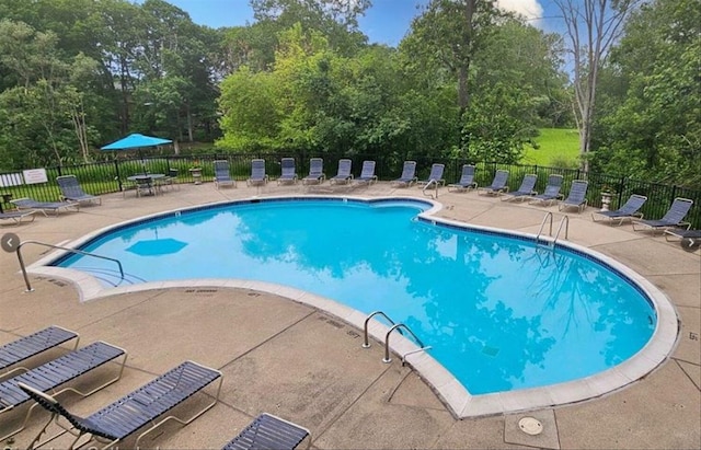 community pool featuring fence and a patio area