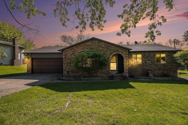 view of front of house with brick siding, a front yard, driveway, and a shingled roof