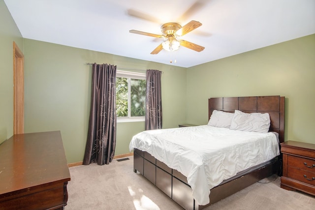bedroom featuring light colored carpet, baseboards, and ceiling fan