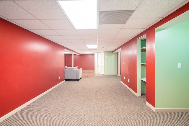 finished basement featuring carpet, baseboards, and a drop ceiling