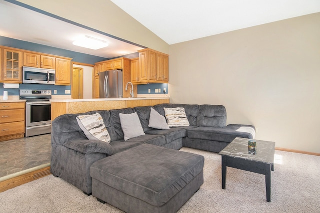 living area with light colored carpet, lofted ceiling, and baseboards