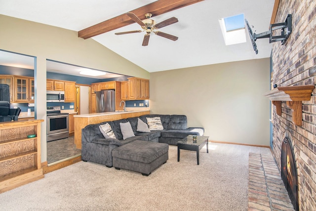 living area featuring a brick fireplace, ceiling fan, baseboards, light carpet, and a skylight