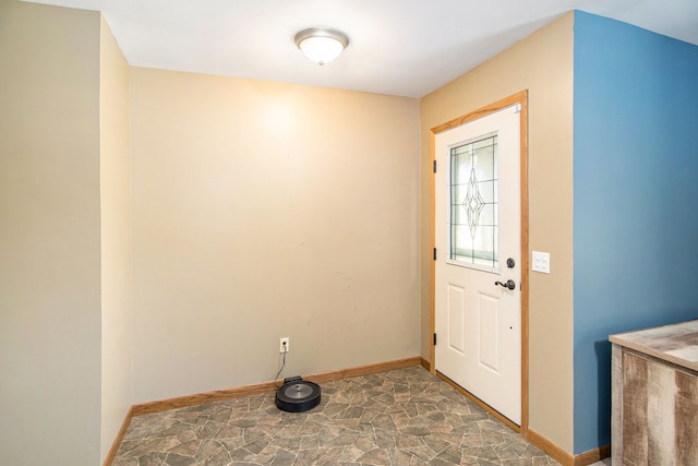 entryway featuring stone finish floors and baseboards