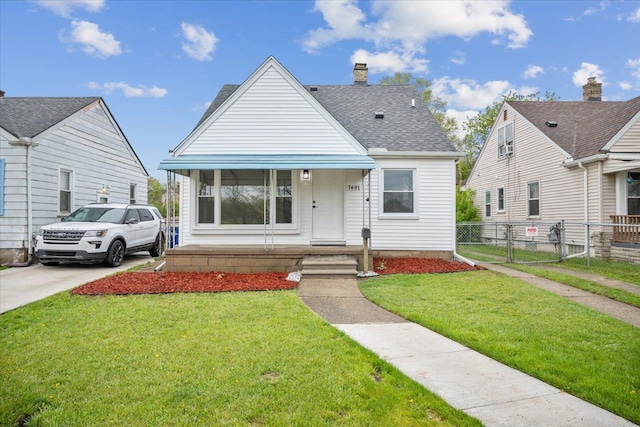 view of front facade featuring a porch, a chimney, fence, a front lawn, and a shingled roof