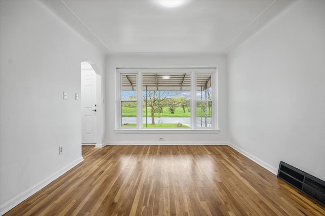 unfurnished room with visible vents, baseboards, and wood finished floors