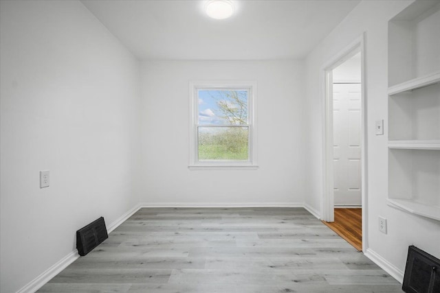 unfurnished dining area featuring baseboards, wood finished floors, and visible vents