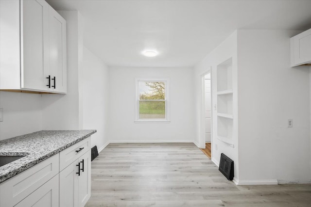 interior space featuring baseboards and light wood-style flooring