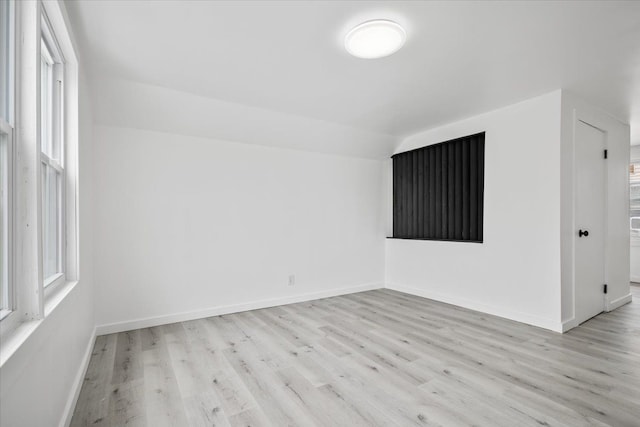unfurnished room featuring baseboards, a healthy amount of sunlight, and wood finished floors