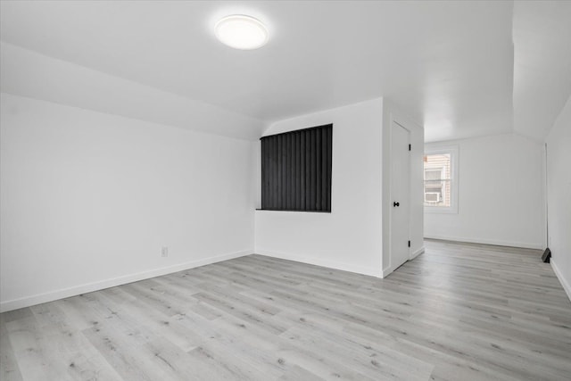 additional living space featuring wood finished floors, baseboards, and lofted ceiling