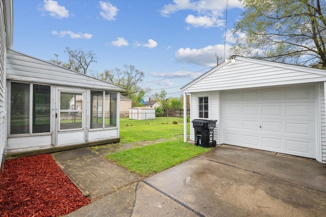 detached garage featuring fence and driveway