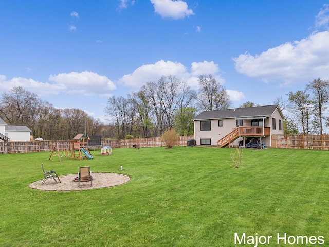 view of yard featuring a fenced backyard, a playground, and stairs