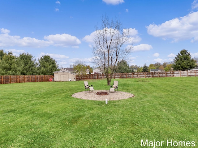 view of yard with an outdoor structure, a fire pit, a fenced backyard, and a shed