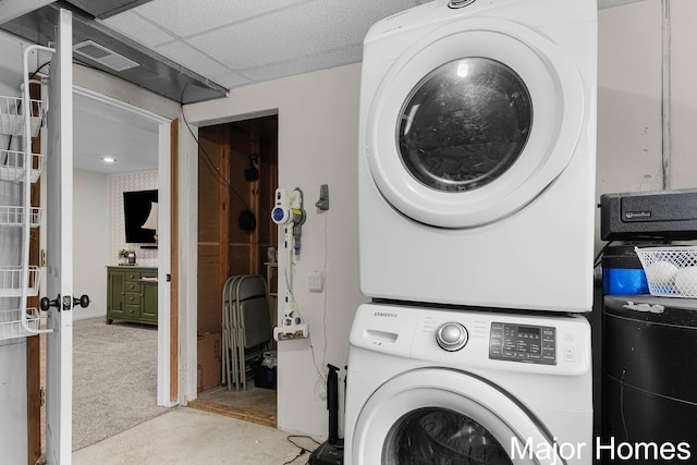 washroom with carpet floors, stacked washer and clothes dryer, and visible vents