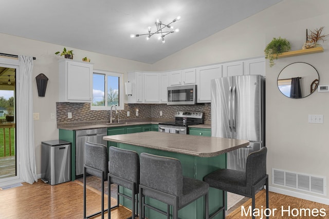 kitchen with visible vents, white cabinetry, backsplash, and stainless steel appliances