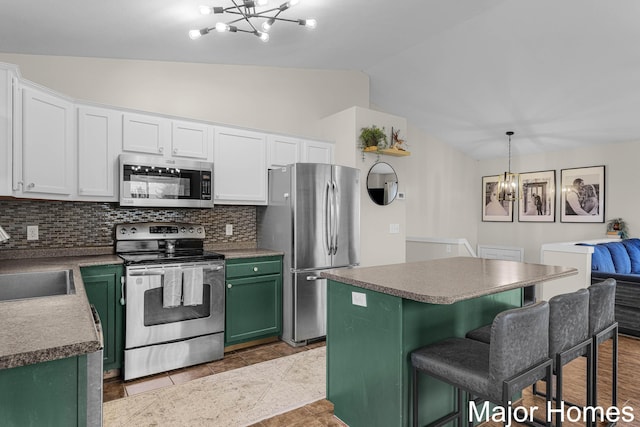 kitchen featuring green cabinets, stainless steel appliances, lofted ceiling, and a chandelier