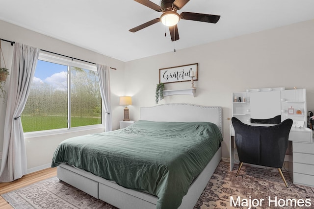bedroom with baseboards, ceiling fan, and wood finished floors