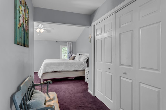 bedroom featuring ceiling fan, dark colored carpet, baseboards, lofted ceiling, and a closet