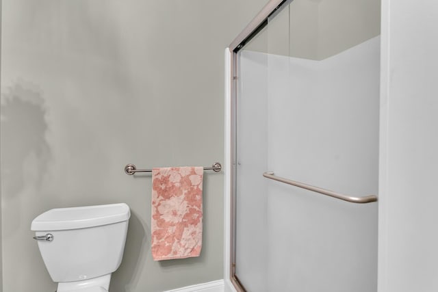 full bath with toilet and a shower with door