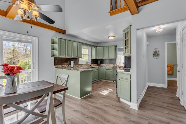 kitchen with ceiling fan, open shelves, light wood finished floors, tasteful backsplash, and green cabinets